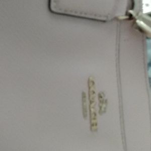 Coach blush pink purse with three slots.